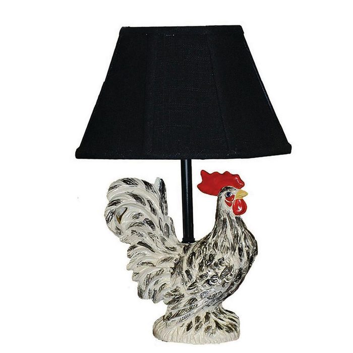 A decorative lamp shaped like a rooster stands upright, illuminated by a black fabric shade, adding a whimsical touch to a cozy setting.