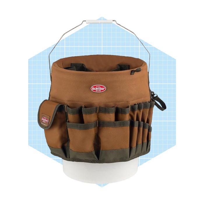A brown, canvas tool organizer sits on a white surface, featuring multiple pockets and a handle for carrying, set against a light blue geometric background.