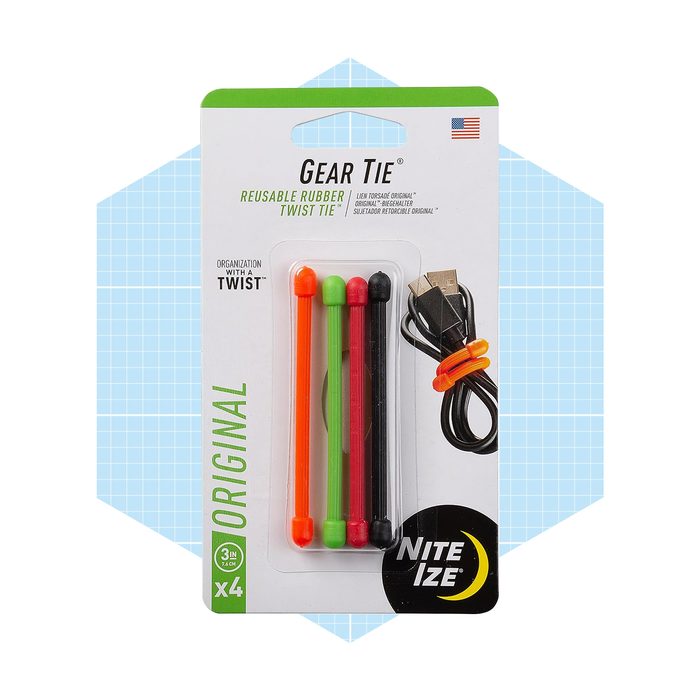 A package contains four reusable rubber twist ties in various colors: orange, green, black, and red, alongside a bundled black USB cable against a blue grid background.