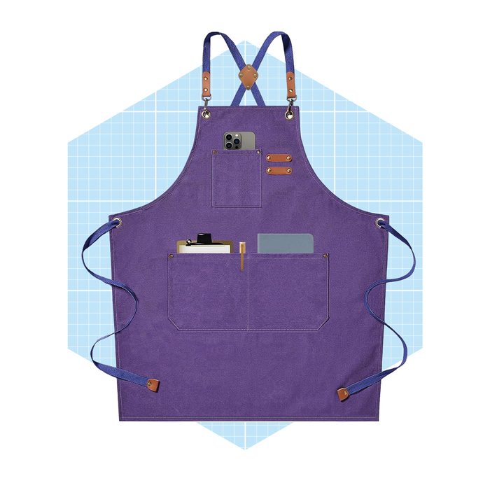 A purple apron with multiple pockets hangs against a light blue grid background, showcasing functionality for tools or materials.
