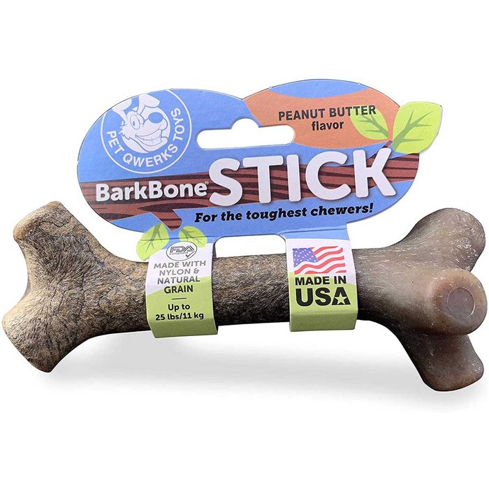 A durable, peanut butter-flavored dog chew toy shaped like a bone is packaged with colorful labels indicating its materials and suitability for strong chewers.