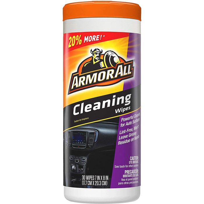 Cleaning wipes in a container are positioned upright. The container advertises features like being lint-free and safe for auto surfaces, with cautionary notes.