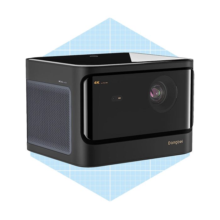 A sleek, black 4K projector sits angled, showcasing its lens and lighting features, against a light blue geometric background.