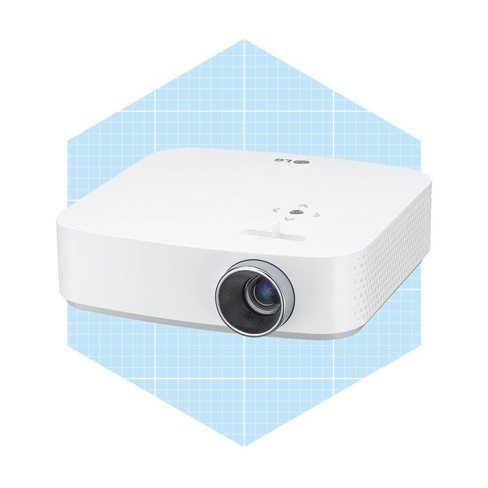 A white projector sits in the foreground, designed for displaying images, against a light blue grid-patterned background.