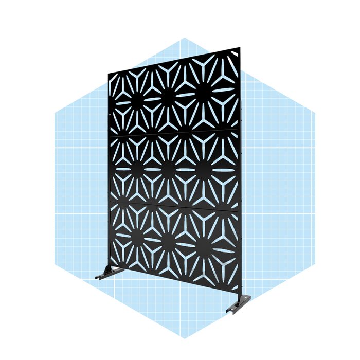A black decorative panel stands upright, featuring an intricate geometric design, set against a light blue grid background.