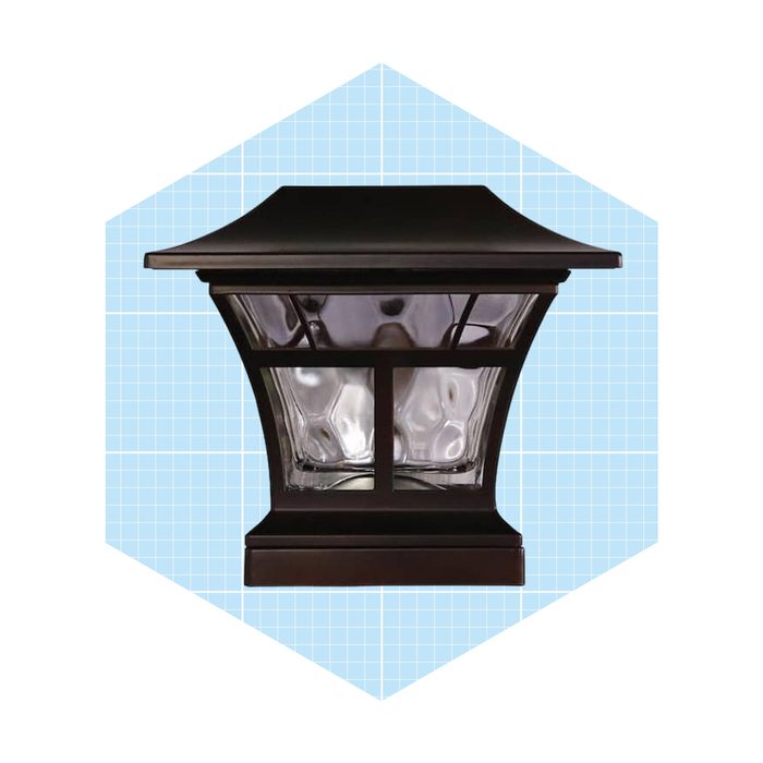 A decorative outdoor lantern stands upright, illuminating its surroundings, set against a light blue grid background with a hexagonal shape.