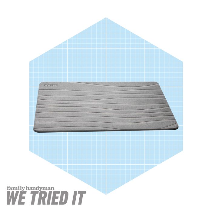 A gray mat with textured waves rests on a light blue grid background, suggesting a clean and modern design intended for home use.