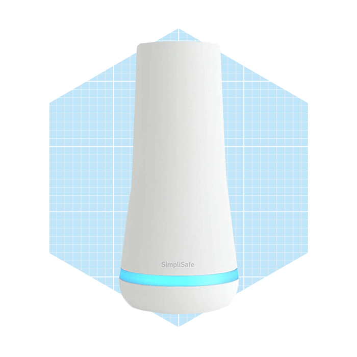 A white cylindrical device emits a soft blue light, standing against a light blue grid background, likely serving as a home security device.