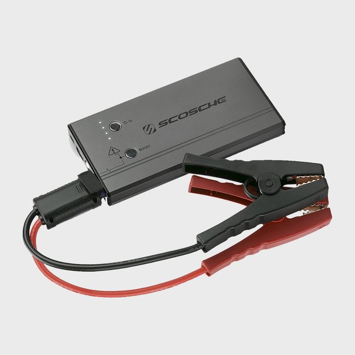 A portable battery jumper featuring clamps, charging ports, and indicator lights, positioned against a neutral background, intended for jump-starting vehicles.