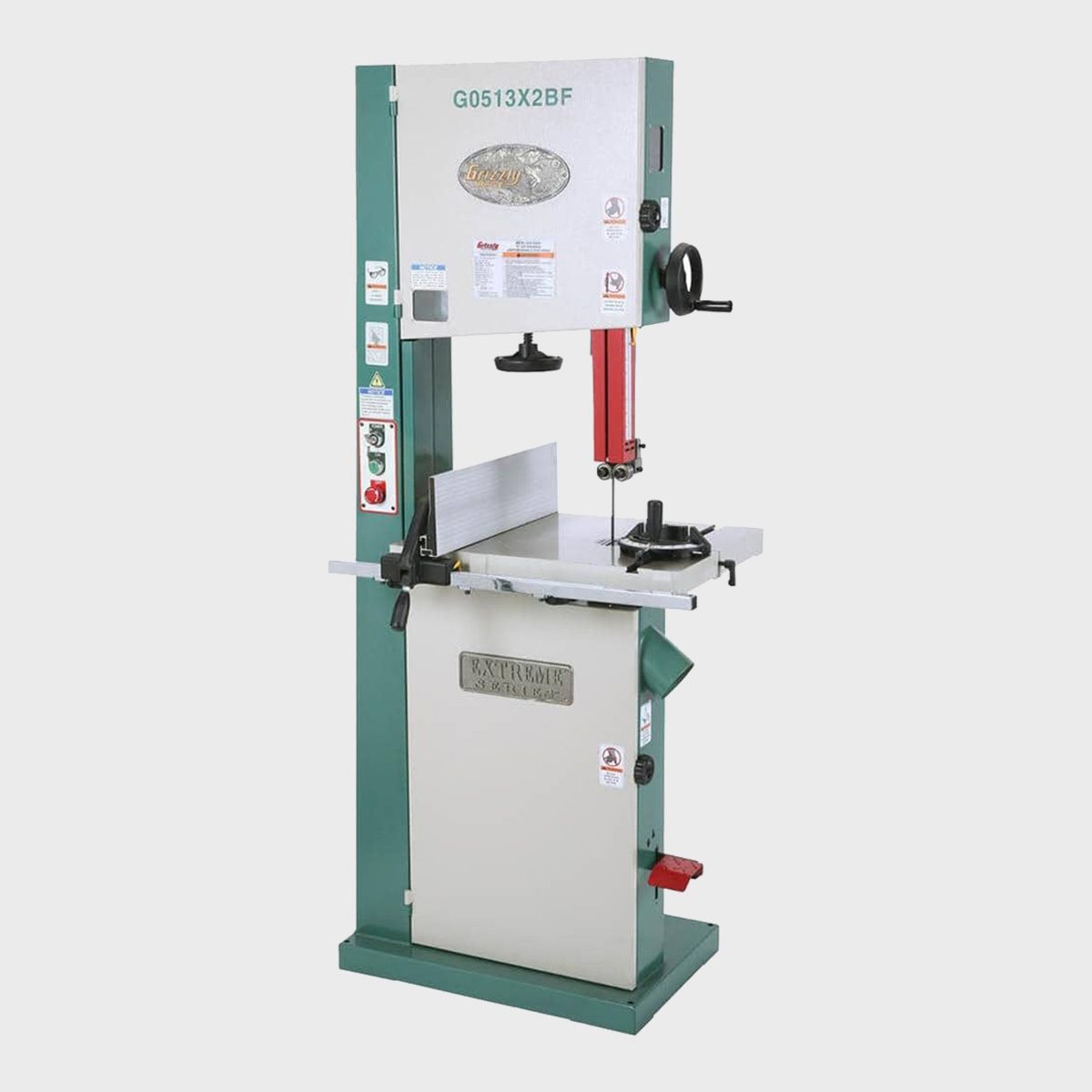 A bandsaw stands upright, featuring a vertical blade and a flat table for cutting materials, situated in a neutral, uncluttered environment.
