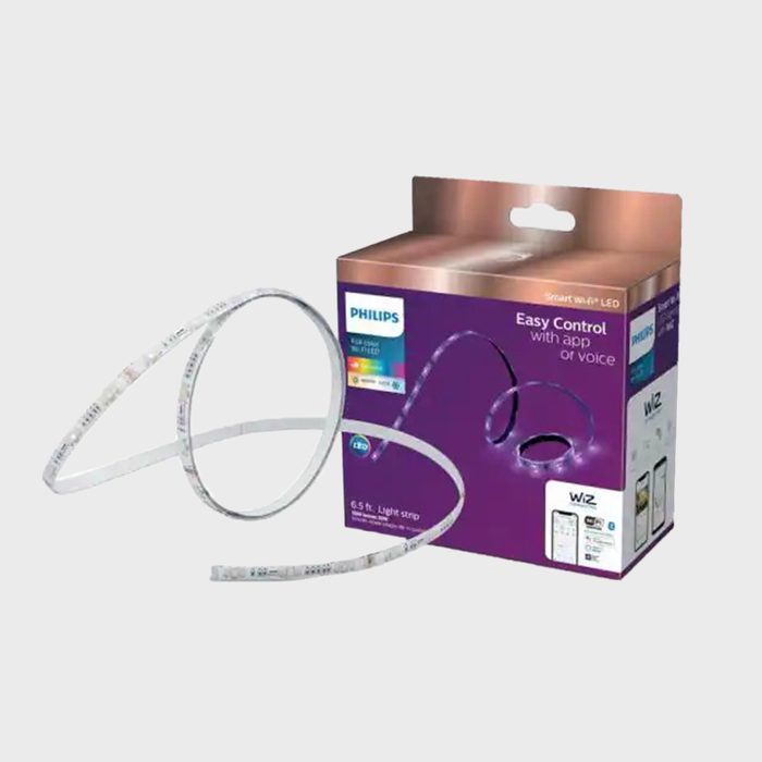 A flexible LED light strip lies next to its packaging, showcasing its design for smart control via app or voice in a neutral background.