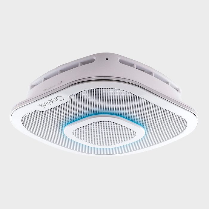 A ceiling-mounted air purifier filters air while illuminated by a subtle blue light, designed for indoor spaces with a clean, modern aesthetic.