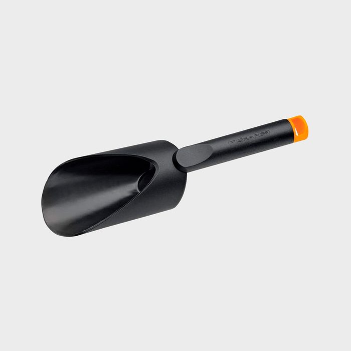 A black scoop with a wide open bowl and an orange tip handle rests against a light gray background, designed for easily transferring materials.
