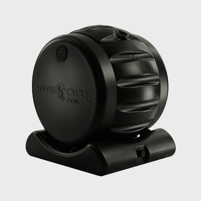 A black compost tumbler is positioned upright on a base, designed for rotating organic waste to accelerate composting in a home or garden setting.