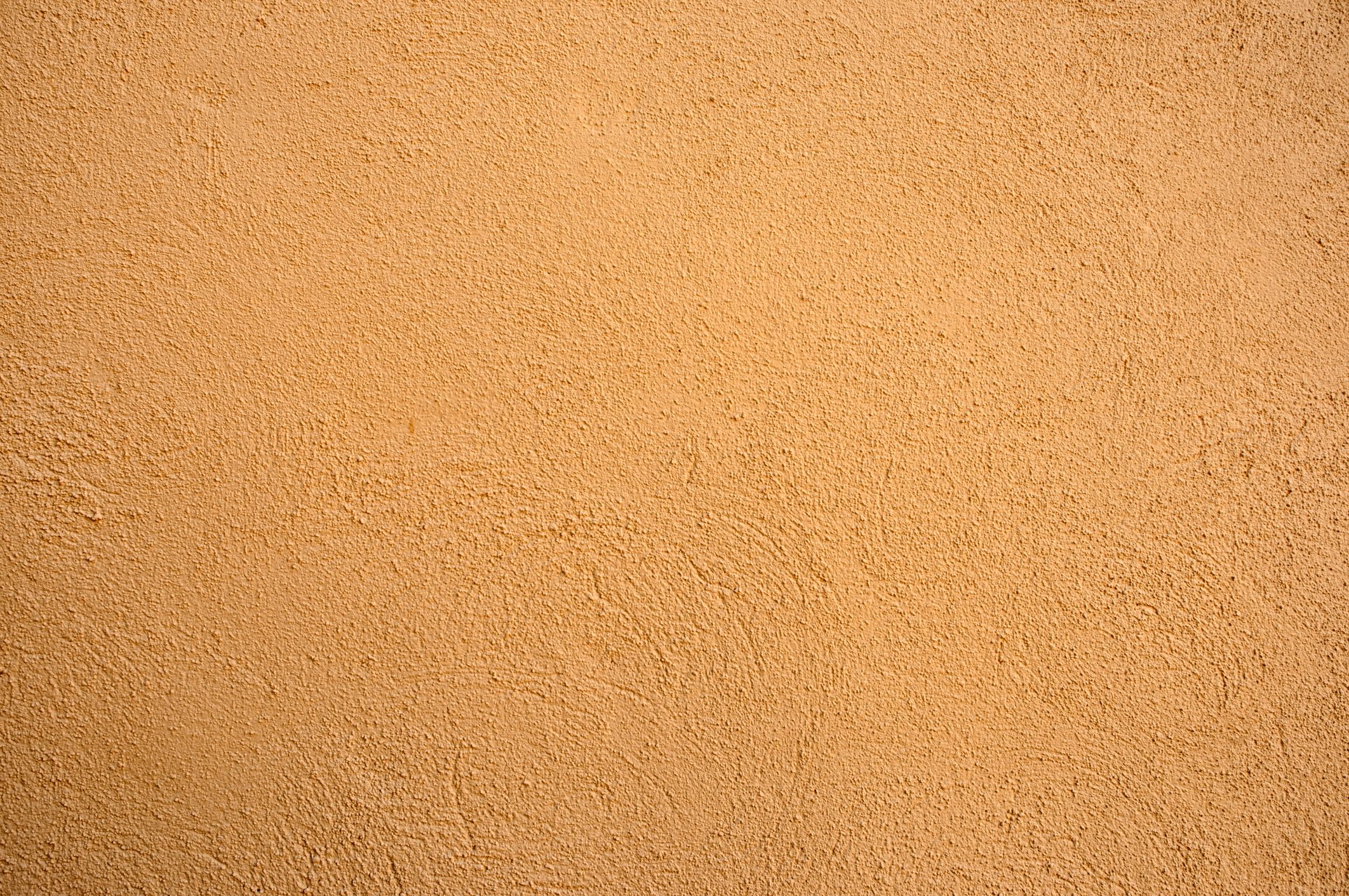 A textured, ochre wall occupies the space, providing a warm, neutral backdrop without any visible features or objects interacting within the environment.