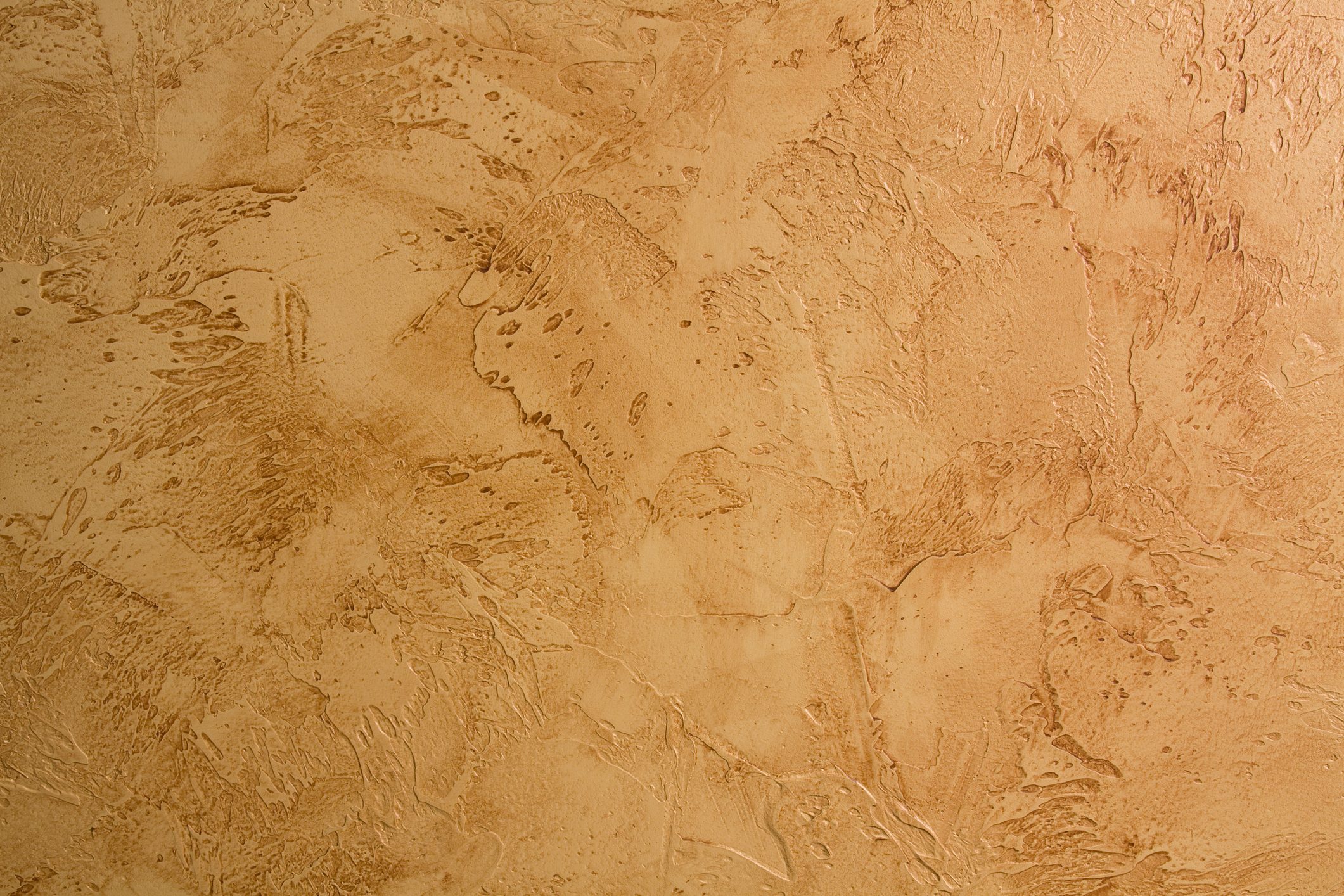 A textured, light brown surface displays various patterns and grooves, creating a visually dynamic backdrop that suggests depth and warmth.