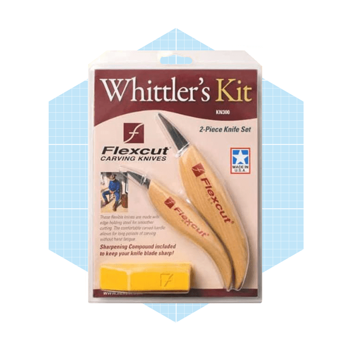 A two-piece whittling knife set is displayed in packaging, featuring curved blades and wooden handles, positioned against a light blue grid background.