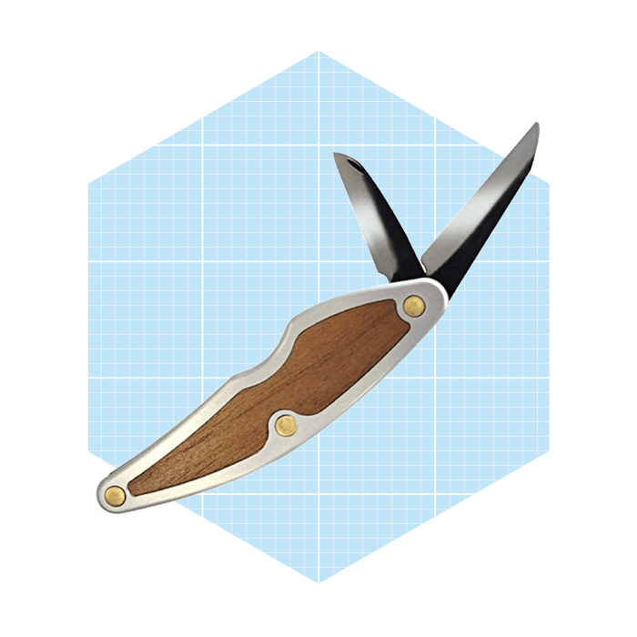 A folding knife with a wooden handle and two exposed blades rests against a light blue grid-patterned background.