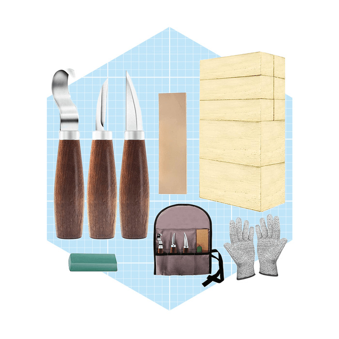 Carving tools, gloves, and wood blocks are arranged on a light blue grid background, indicating preparation for a woodworking project.