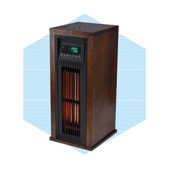 A wooden electric heater displays a digital temperature reading, emitting warmth through visible heating elements, set against a light blue geometric background.