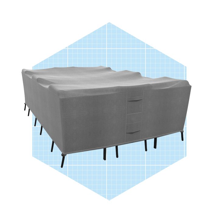 A gray sofa with a textured surface rests on slender black legs, set against a light blue grid-patterned background.