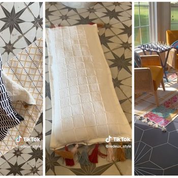 Three patterned textiles are arranged for display on a decorative floor, surrounded by a cozy interior with a chess set and vibrant seating.