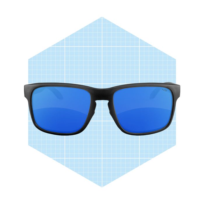 Sunglasses with blue lenses are displayed centrally against a light blue, grid-patterned hexagonal background.