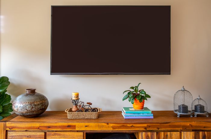 A wall mounted TV above a sideboard