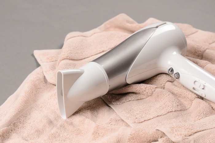 White hair dryer on beige towel